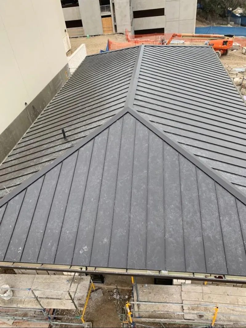 Commercial metal roof construction with crane equipment in North Arlington